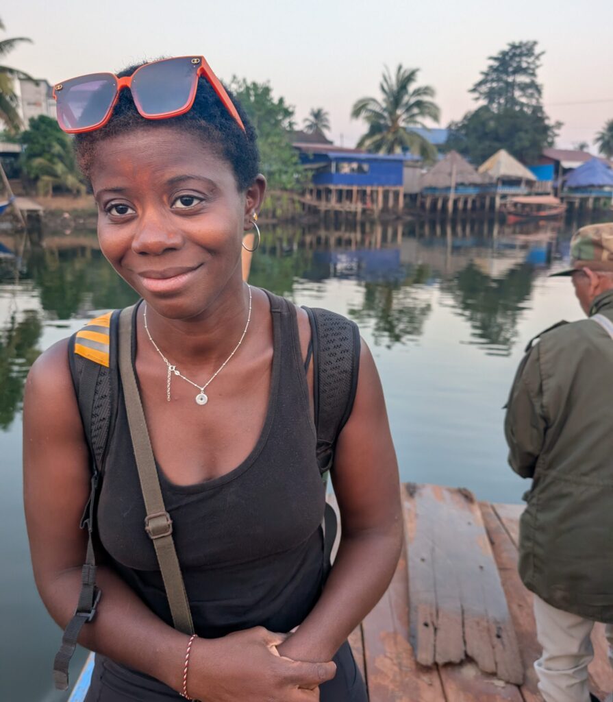 Mary-Ann standing on a wooden raft looking tired.