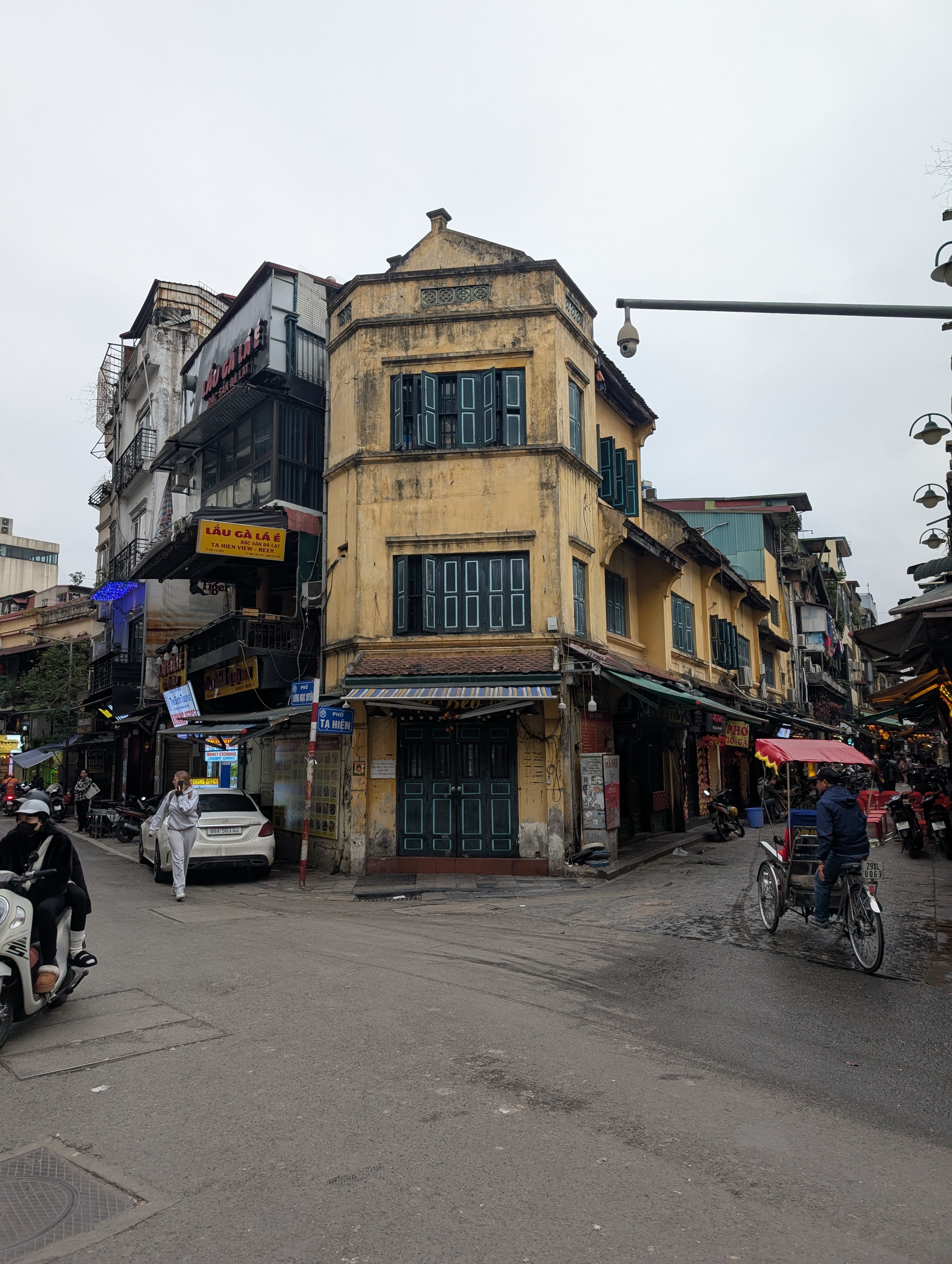 An old yellow colonial building on a corner in the Hanoi old quarter.