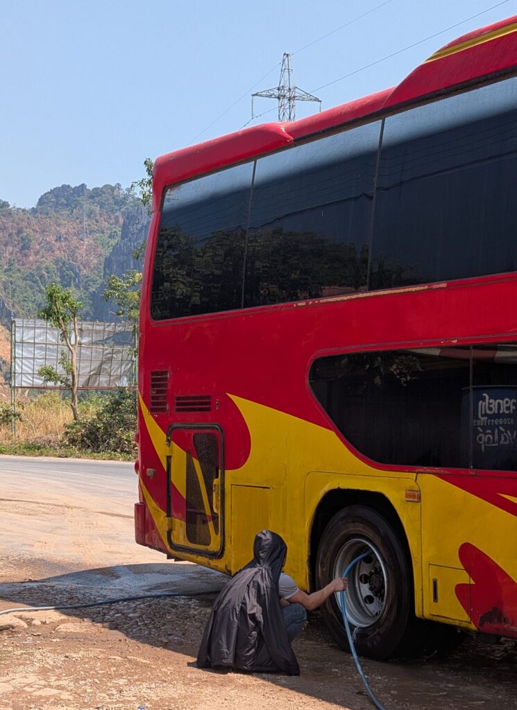 A photo of our bus driver hosing down the buses brakes because the got so hot during the mountain pass descent.