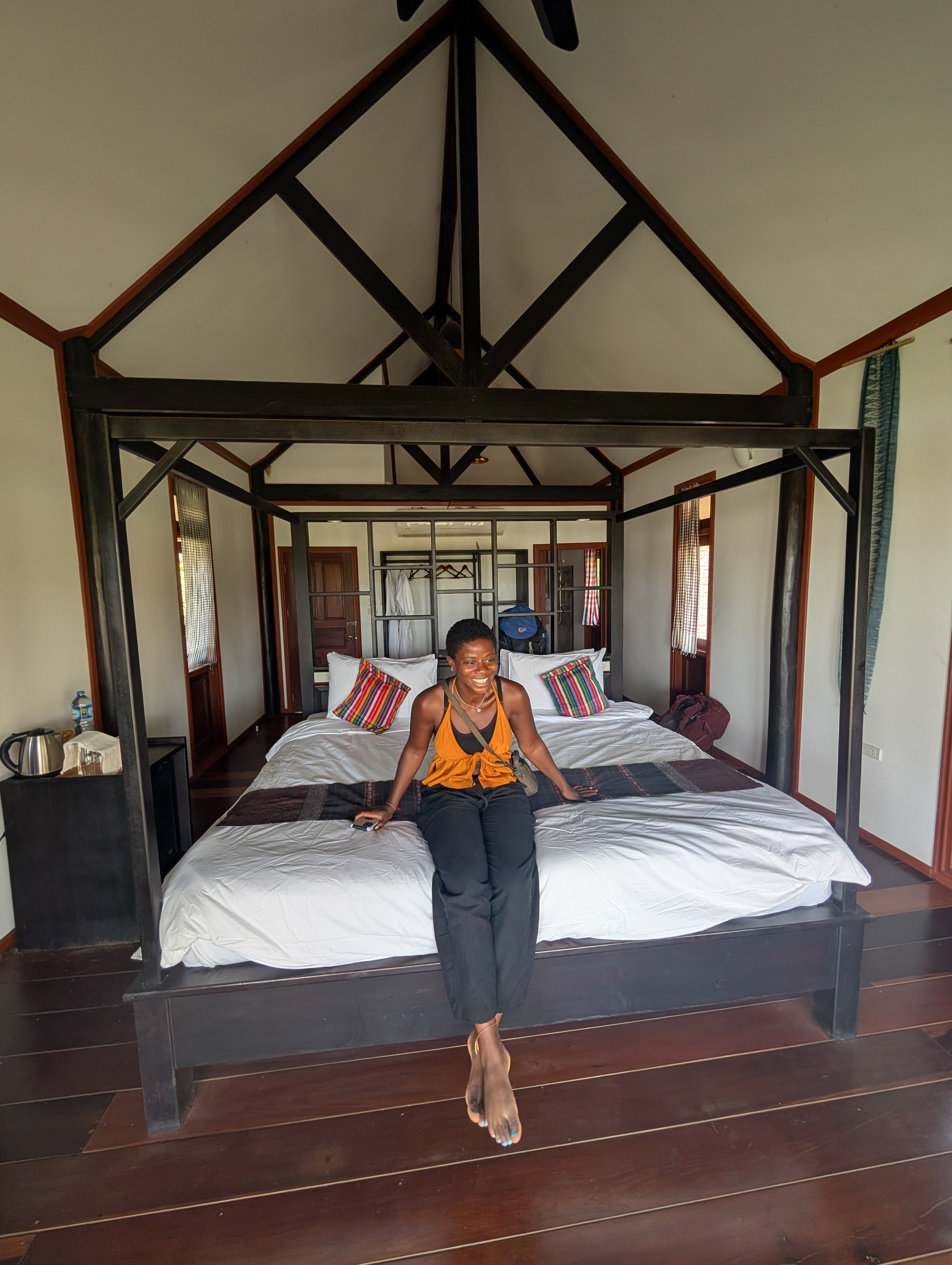 Mary-Ann sitting at the foot of a king size bed at the Kingfisher Lodge.