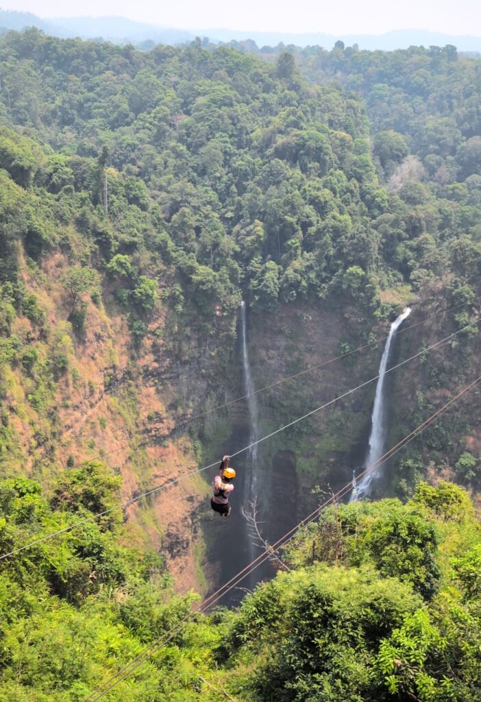 Mary-Ann riding a zipline over an enormous water fall on the Pakse Loop.