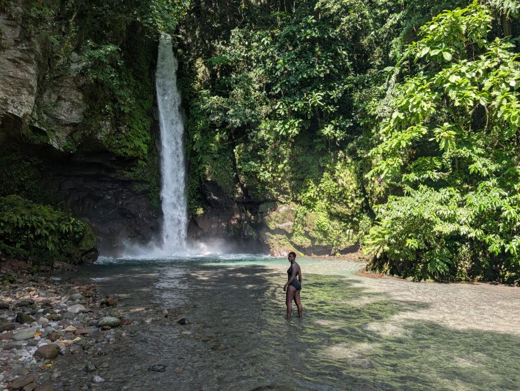 Mary-Ann wading into a chilly pool at the bottom of a waterfall.