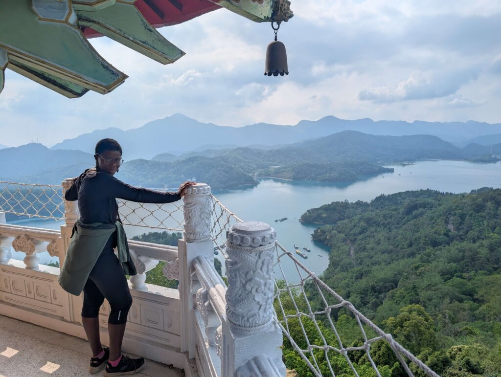Mary-Ann standing on the highest level of a pagoda, looking over the Sun Moon lake.
