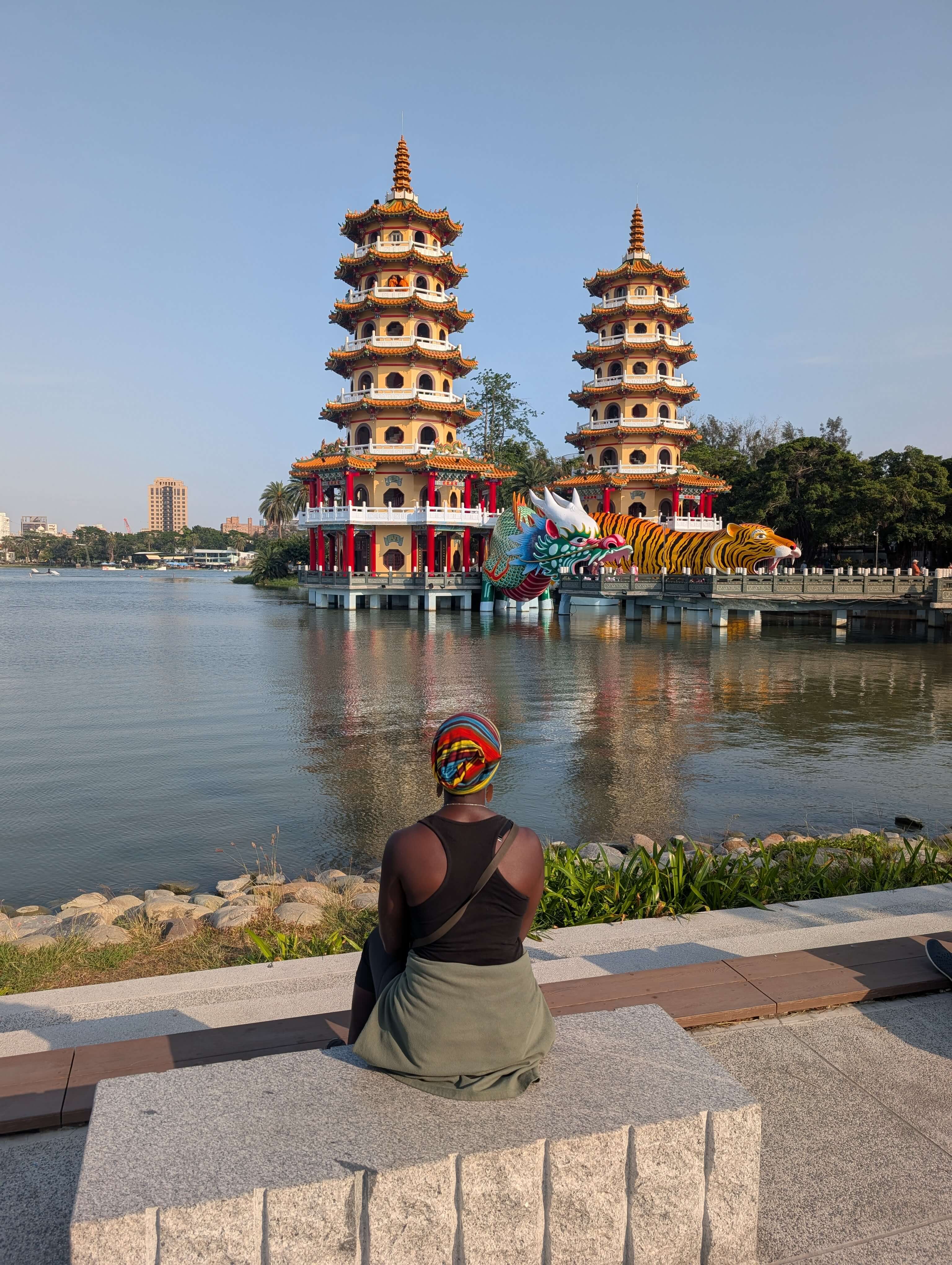 Mary-Ann sitting on a bench overlooking the Lotus Pond in Kahsiung, with the twin-pagodas in the background.