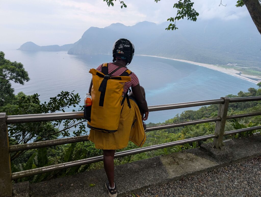 An image of Mary-Ann standing at the roadside, looking over a bay enroute to Taipei.
