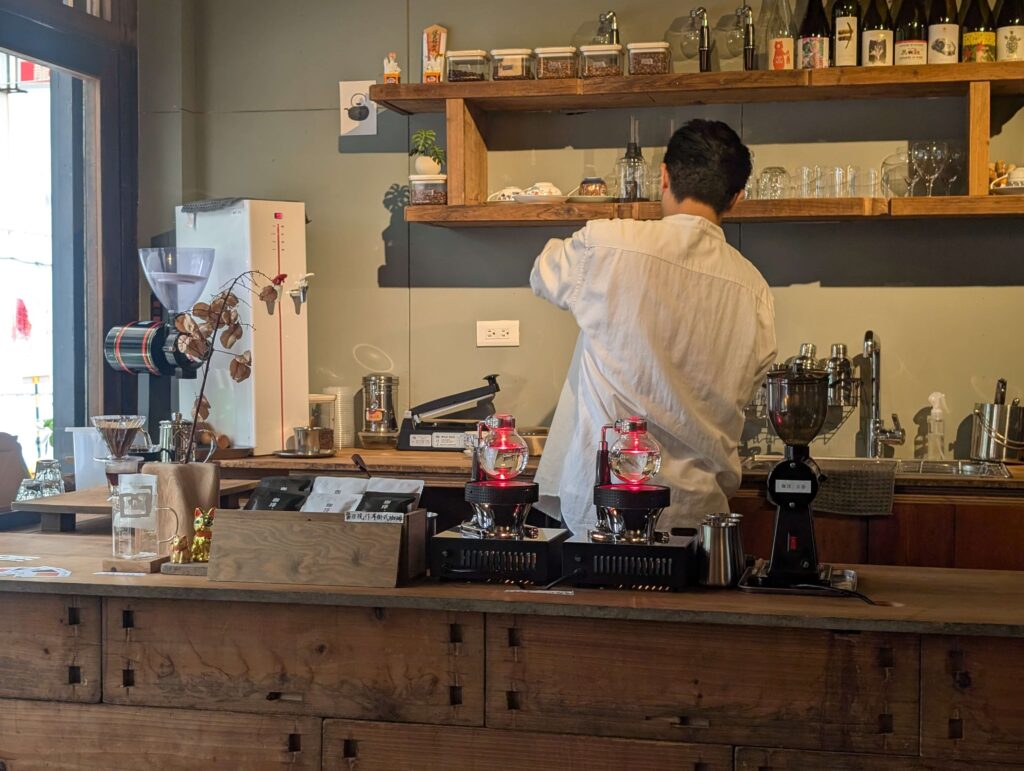 An image over the bar at a coffee spot, showing glass bottles and fancy gizmos.
