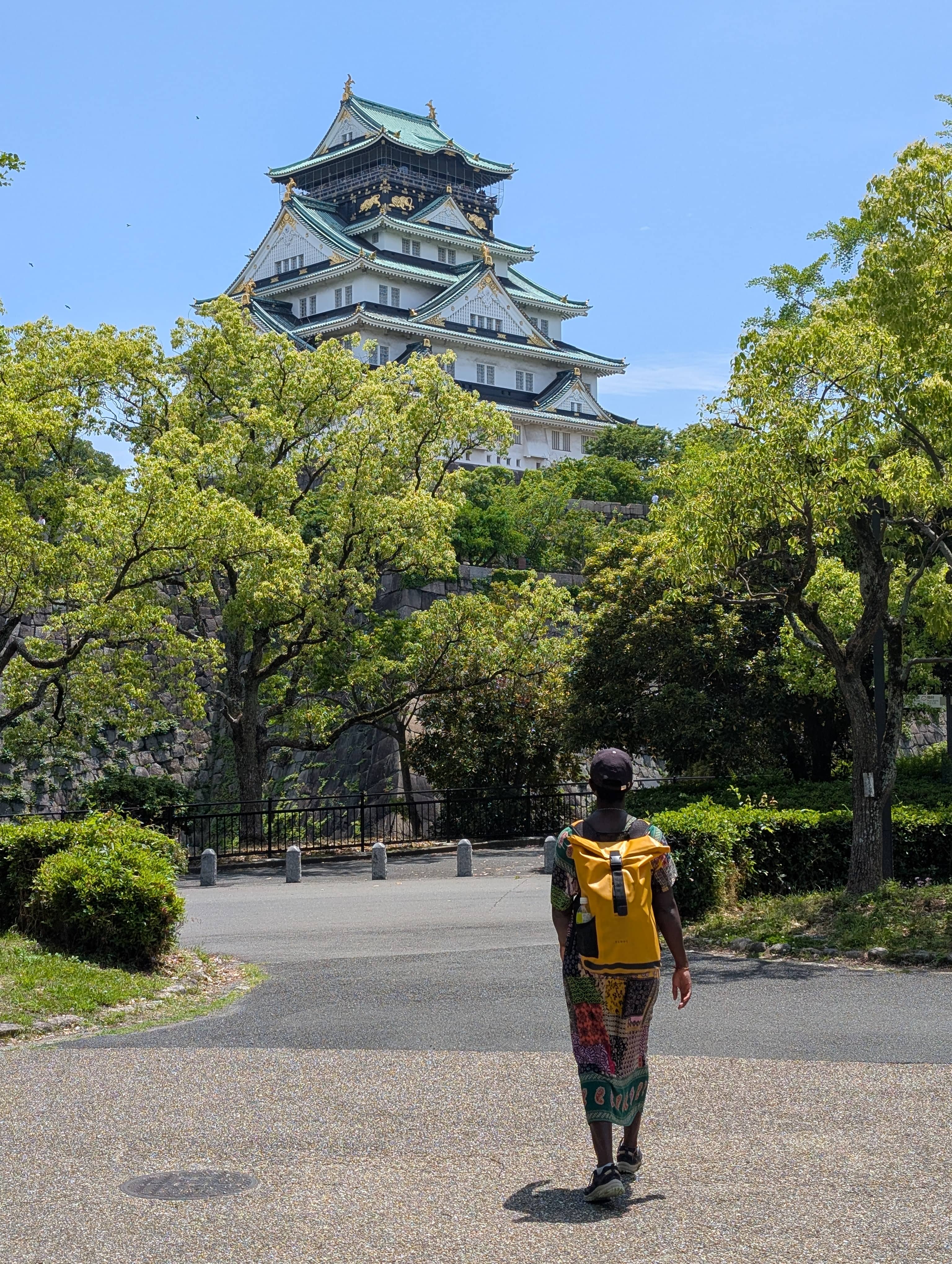 An image of Mary-Ann walking towards Osaka Castle in the distane.