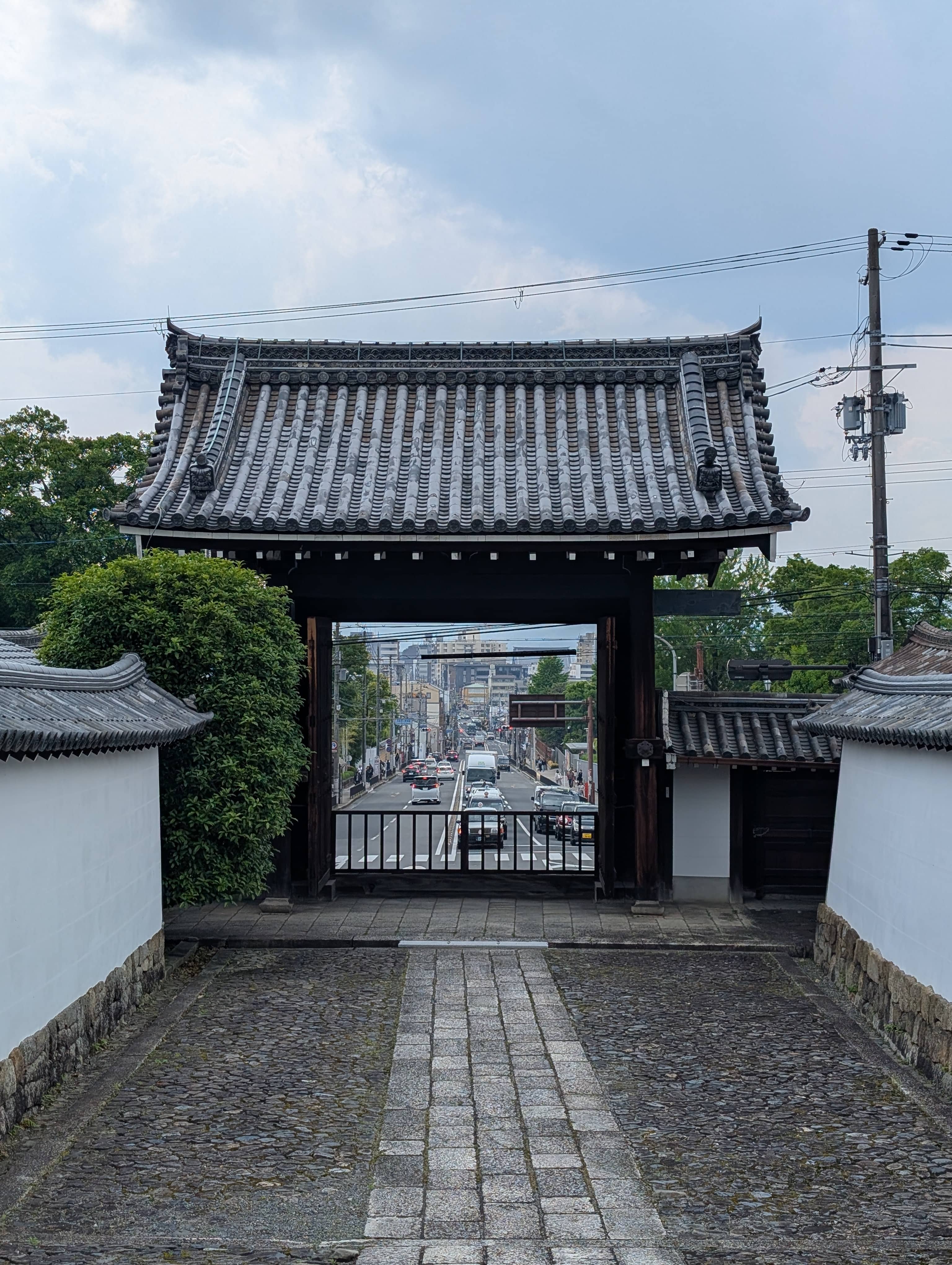 An image of a view through a traditional gate, down a long straight street in Kyoto.